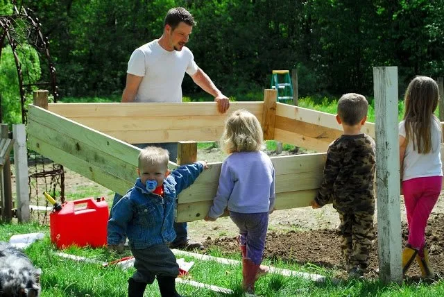 young man and children moving raised bed