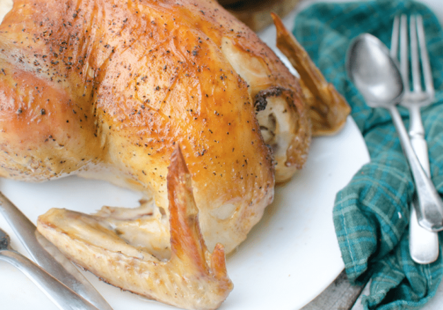 whole roasted chicken on white plate