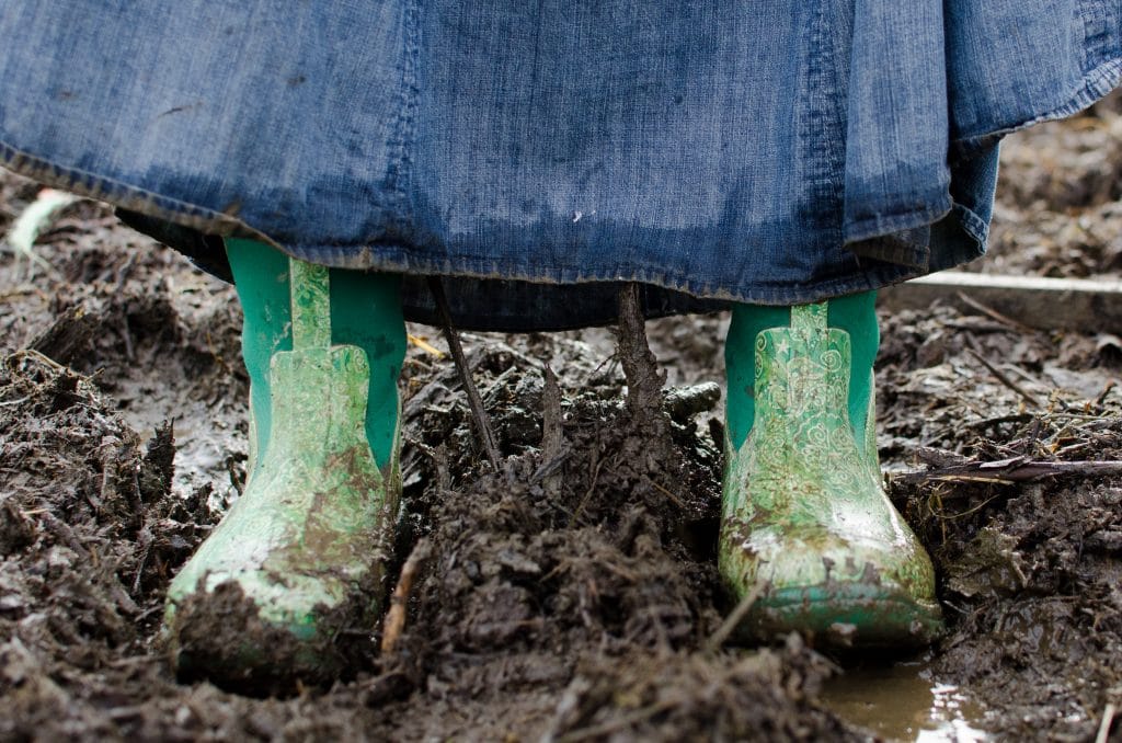 lady in green rubber boots in mud
