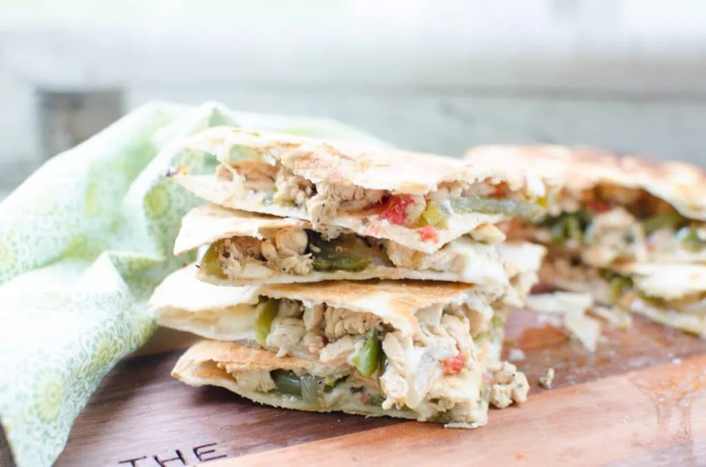 Chicken Quesadillas are a quick weeknight meal of seasoned chicken breasts, tomatoes, peppers, and monterey cheese toasted between two crispy tortillas.