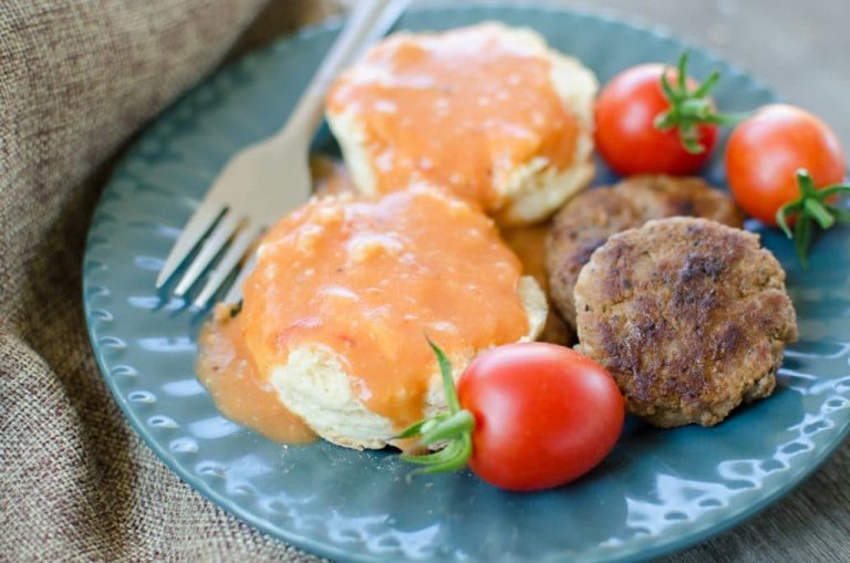 tomato-gravy on biscuits on a blue plate with fork