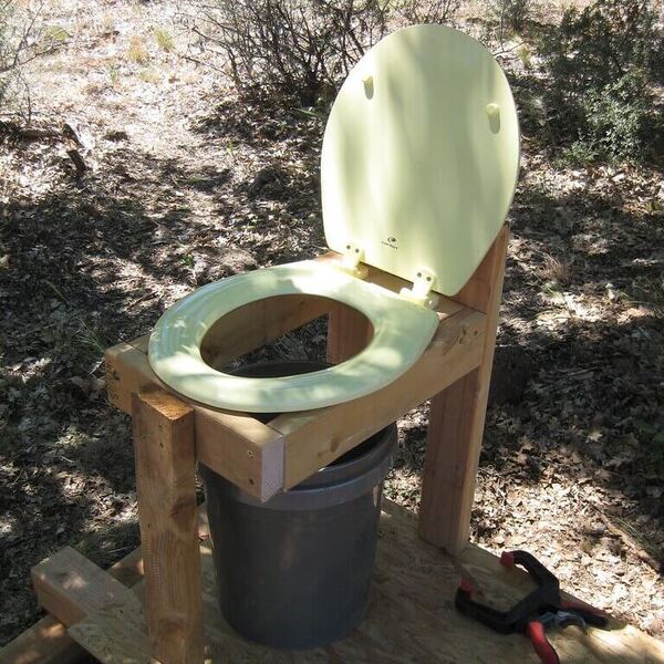 toilet bowl using a pail in the backyard