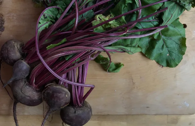 5 beets laying on a cutting board