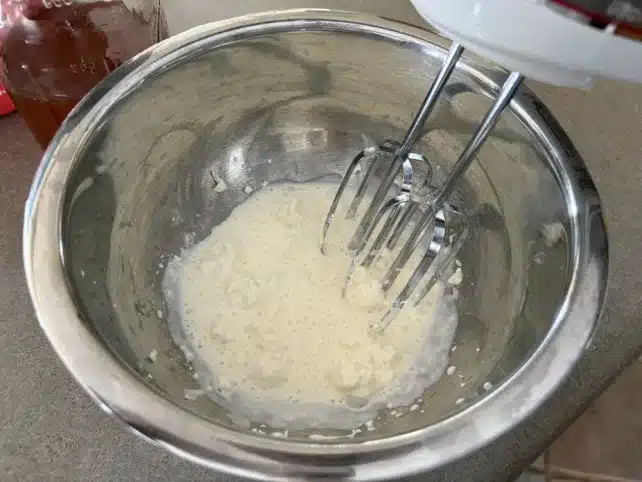 mixing cream cheese and heavy whipping cream in a bowl