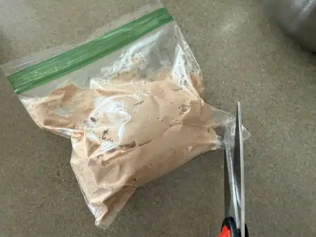 clipping the corner of the bag to pipe the chocolate protein mixture