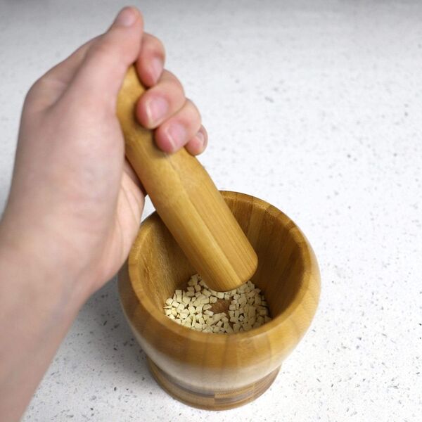 a hand curshing some garlic