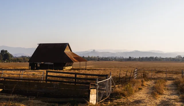 a picture of a field and a barn for homestead management